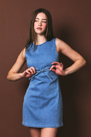 Woman wearing a blue dress against a brown background