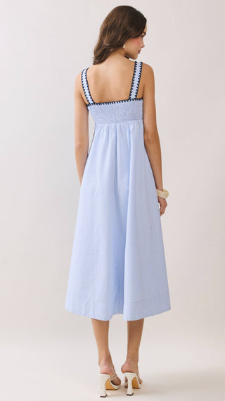 Woman wearing a light blue dress with thin straps on a white background
