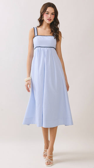 Woman wearing a light blue dress with white straps on a white background