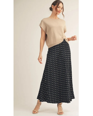 Woman modeling the black Alena Polka Dot Satin Maxi Skirt with a neutral short-sleeve top.