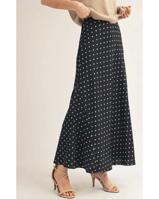 Front view of the black Alena Satin Maxi Skirt featuring a classic white polka dot print and flowy silhouette.
