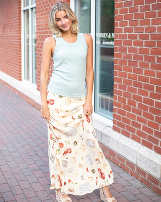 Model wearing the Alena Portofino Slip On Midi Skirt featuring a Mediterranean-inspired seafood and coastal food print with a flattering slip-on midi silhouette.