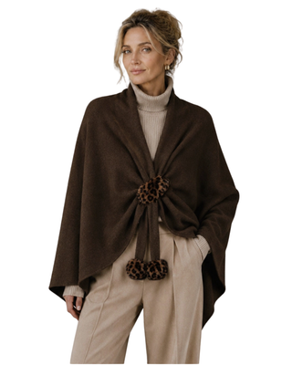 Chocolate brown women's wrap with leopard print faux fur pom-pom tie closure, styled over a beige turtleneck and neutral trousers.