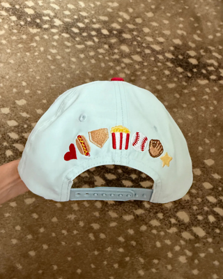 Back view of the baseball trucker hat featuring an adjustable snapback closure and colorful baseball details.