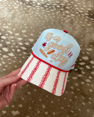 Front view of the light blue and red baseball trucker hat featuring an “It’s a Good Day for Baseball” design.