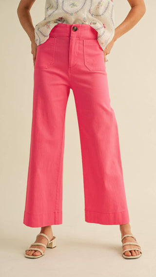 Woman wearing bright pink wide legged trousers high waisted with wide front pockets