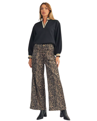 Women’s black textured V-neck top with cream and tan striped neckline, long balloon sleeves, and coordinating striped cuffs.