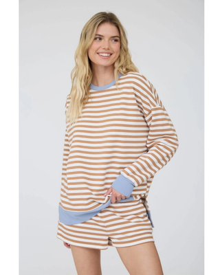 A woman modeling a matching lounge set consisting of a long-sleeve top and shorts in a beige and white horizontal stripe pattern with light blue ribbed trim.
