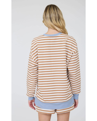 A woman modeling a matching lounge set consisting of a long-sleeve top and shorts in a beige and white horizontal stripe pattern with light blue ribbed trim.