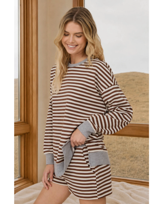 A woman modeling a matching lounge set consisting of a long-sleeve top and shorts in a brown and white horizontal stripe pattern with gray ribbed trim.