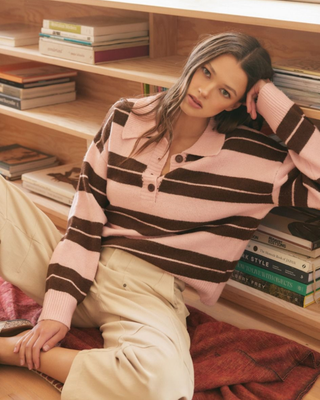 Women's blush pink and mocha brown striped knit sweater featuring a collared button neckline, relaxed fit, and rugby-inspired design.
