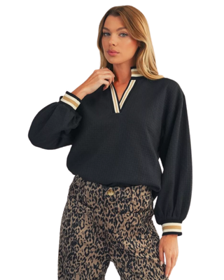Women’s black textured V-neck top with cream and tan striped neckline, long balloon sleeves, and coordinating striped cuffs.