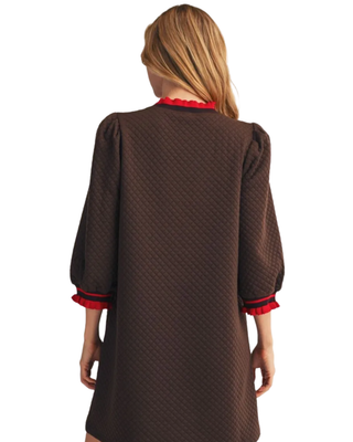 Women’s chocolate brown quilted shift dress with 3/4 puff sleeves and red ruffle trim at the neckline and cuffs.
