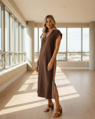 Women's chocolate brown maxi dress with varsity stripe trim at the V-neckline, coordinating striped side panels, short sleeves, and side slits.