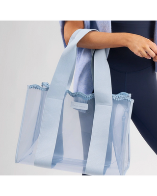 Light blue translucent jelly tote bag with wide woven handles and detachable clear phone pouch.