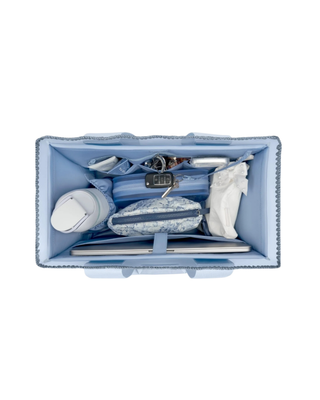 Light blue Case-Mate tote organizer insert with multiple interior pockets holding a phone, sunglasses, water bottle, and everyday essentials.