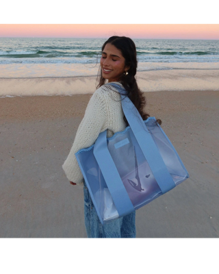 Light blue translucent jelly tote bag with wide woven handles and detachable clear phone pouch.