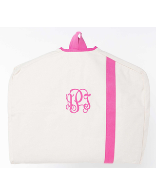 Cream canvas personalized garment bag with hot pink trim, vertical accent stripe, and embroidered monogram, ideal for travel and clothing storage.