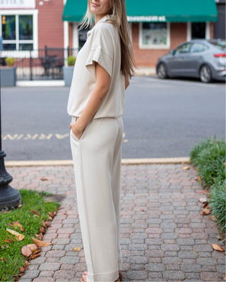 Model wearing neutral beige wide-leg lounge pants with an adjustable drawstring waistband and front seam detailing.
