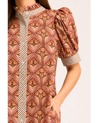 Rust and blush floral print midi dress with puff sleeves, ruffled neckline, gingham trim, button-front detail and side pockets.