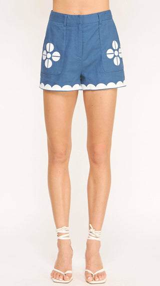 Blue shorts with white floral patterns on a white background