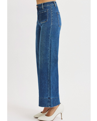 Risen high rise crop wide leg jeans in a dark blue wash featuring front patch pockets and statement cuffed hems.
