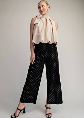 Woman wearing high waisted black polka dot denim wide leg pants