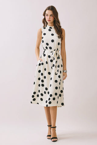 Woman wearing a polka dot dress on a plain background