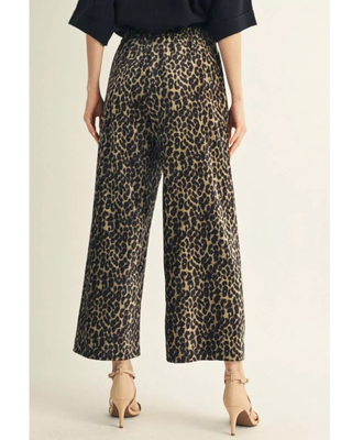 Woman wearing leopard print high-rise wide-leg cropped pants with a black top and neutral heels.