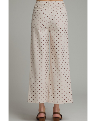 Women's ivory wide-leg pants with a mocha brown polka dot print, high-rise waist, and relaxed silhouette, styled for a chic boutique outfit.