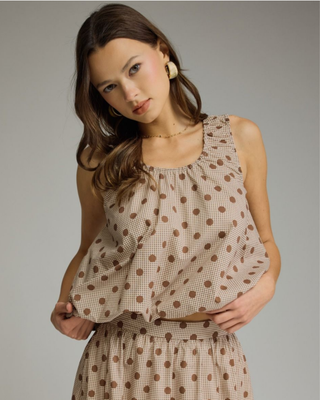 Women's sleeveless mocha polka dot bubble hem blouse with a round neckline and relaxed fit in a lightweight woven fabric.