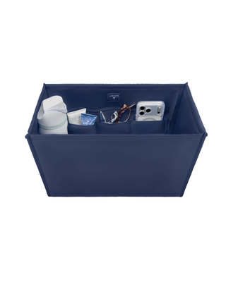 Navy blue tote bag organizer insert with multiple interior pockets holding a water bottle, phone, sunglasses, cosmetics, and everyday essentials.
