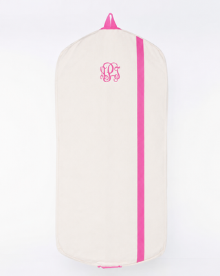 Cream canvas personalized garment bag with hot pink trim, vertical accent stripe, and embroidered monogram, ideal for travel and clothing storage.