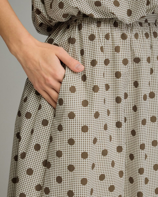 Women's mocha polka dot A-line midi skirt with a high-rise waistband and flowy silhouette in a lightweight woven fabric, styled for an elegant boutique look.