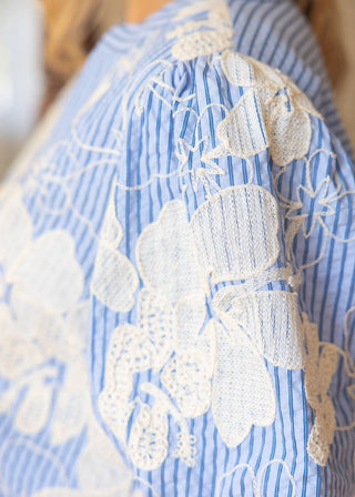 Blue and white striped garment with intricate white lace detailing