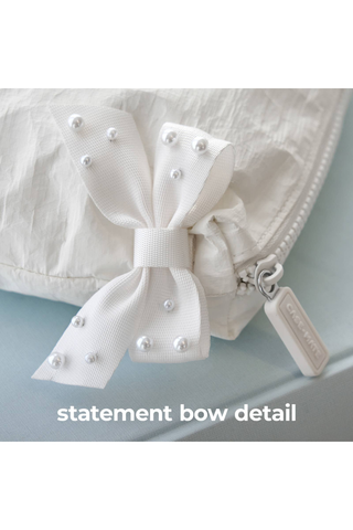 Close-up of the statement bow detail on the Case-Mate Ivory Pearl Bow Crinkle Makeup Bag.