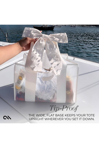 Case-Mate Ivory Pearl Bow Jelly Tote on a boat, showing its wide, flat, tip-proof base that keeps the bag upright.