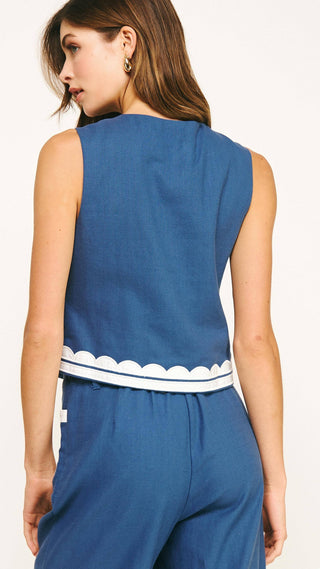 Woman wearing a blue sleeveless top with a white trim back view