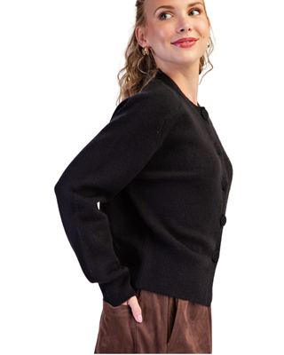 Women’s black knit cardigan with crew neckline, tonal front buttons, long sleeves, ribbed trim and relaxed fit.