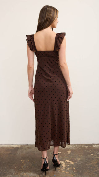 back view of Chocolate brown sweetheart flowy maxi dress with mesh overly of polka dots and ruffle cap short sleeves with elastic band