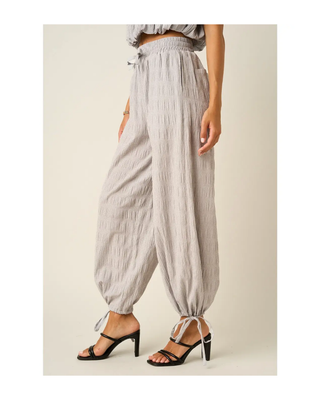 The Maren Jogger Pants in light gray featuring textured fabric, an elastic drawstring waistband, relaxed fit, and adjustable ankle ties.