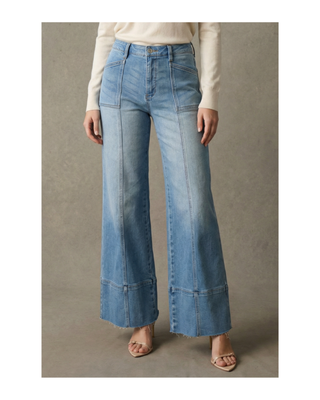 The Sutton Palazzo Jeans featuring eco-friendly light wash stretch denim, a high-rise tummy control waistband, front seam detailing, and a wide palazzo leg with a raw hem.