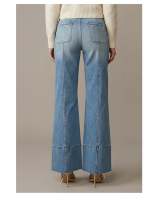 The Sutton Palazzo Jeans featuring eco-friendly light wash stretch denim, a high-rise tummy control waistband, front seam detailing, and a wide palazzo leg with a raw hem.