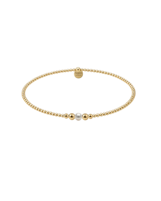 Gold beaded bracelet with single pearl accent worn on wrist, a delicate women’s jewelry accessory.