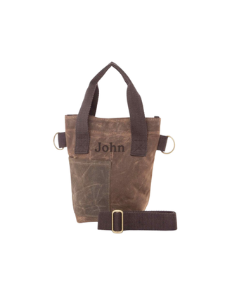 Wine Bottle Tote in Khaki featuring premium waxed canvas, sturdy carry handles, removable shoulder strap, front pocket, and brass hardware for carrying a standard wine bottle.